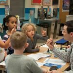 Elliott Neff teaching Boys & Girls Club children how to play chess- Fall 2016. Photo by Sarah Smoots